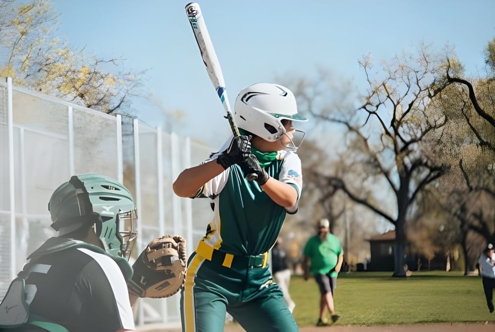 Eine Schülerin in Baseballuniform steht auf dem Spielfeld der St. Joseph Catholic High School.