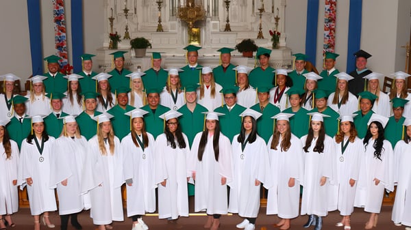 Schüler und Schülerinnen der St. Joseph Catholic High School feiern eine Zeremonie in einem kirchlichen Raum mit religiösen Symbolen.