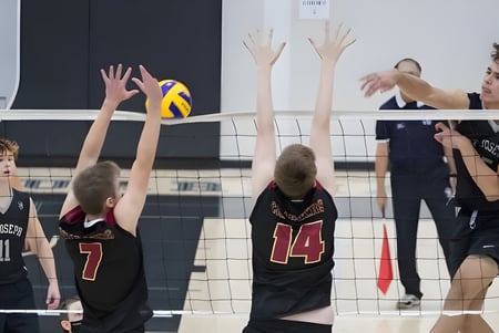 Schülerinnen und Schüler der St. Joseph High School spielen Volleyball und versuchen am Netz den Ball zu blocken.