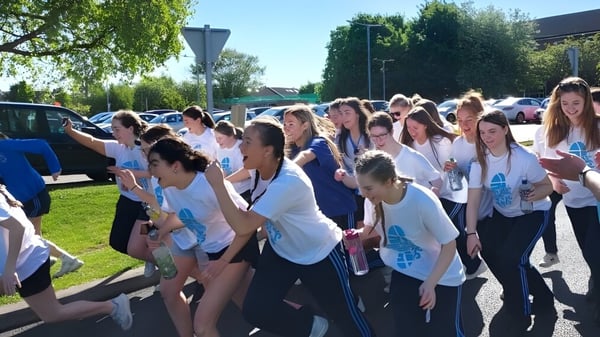 Eine Gruppe junger Menschen steht gemeinsam im Freien auf dem Campus der St. Joseph of Cluny.