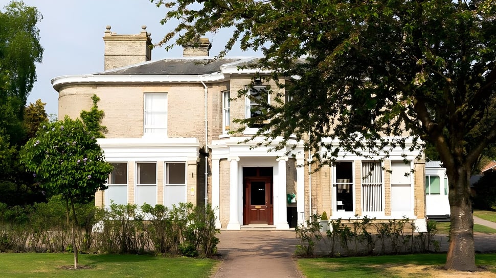 Das zweistöckige Backsteingebäude des St. Joseph's College ist von grünen Bäumen und gepflegtem Rasen umgeben.