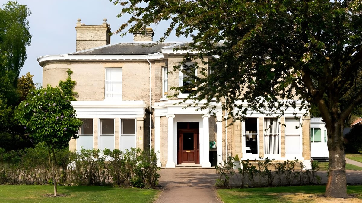 Das zweistöckige Backsteingebäude des St. Joseph's College ist von grünen Bäumen und gepflegtem Rasen umgeben.