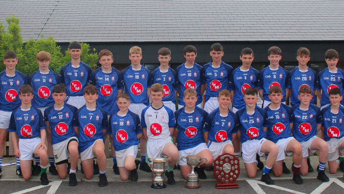 Eine Gruppe von jungen Basketballspielern posiert vor einem Gebäude mit Ziegeldach auf dem Gelände der St. Joseph's Secondary School.
