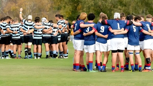 Zwei Rugby-Teams stehen in einer Spielbesprechung auf dem Spielfeld des St. Kevin’s College.