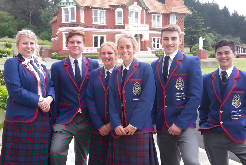 Schüler in Schuluniformen posieren vor dem großen roten und weißen Gebäude auf dem Gelände von St. Kevin’s College.