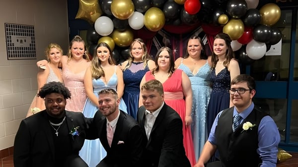 Eine Gruppe von Schülerinnen und Schülern der St. Lawrence Secondary School posiert vor einem bunten Luftballonhintergrund.
