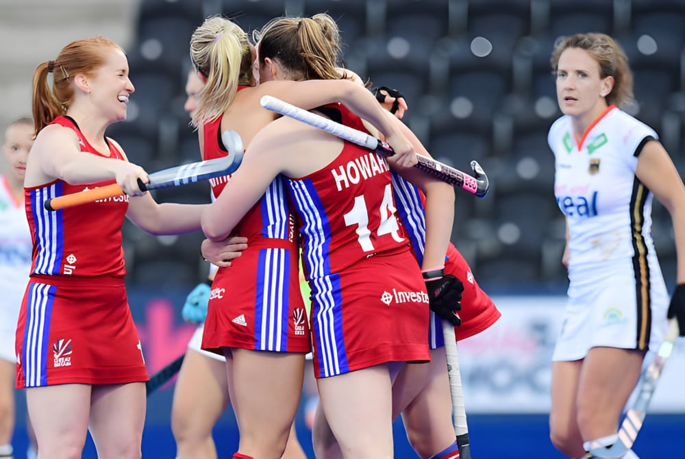 Eine Gruppe von Athletinnen der St. Louis Community School umarmt sich auf dem Sportfeld während eines Spiels.