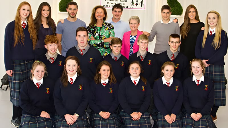Eine Gruppe Schüler der St. Louis Community School posiert zusammen im Klassenzimmer mit pädagogischen Postern im Hintergrund.