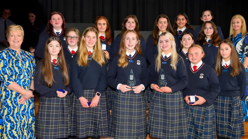 Eine Gruppe Schülerinnen der St. Louis Secondary School posiert gemeinsam vor einem dunklen Vorhang.