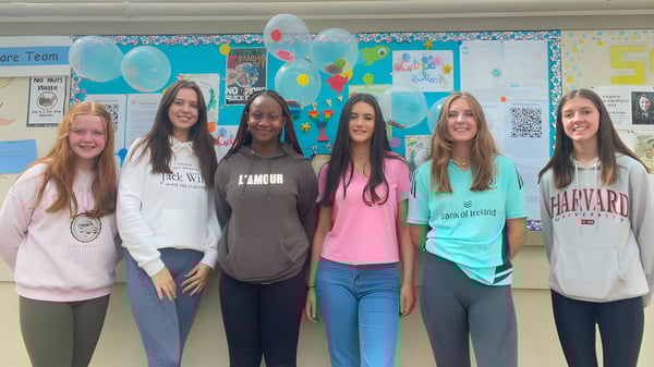 Sechs Schülerinnen stehen gemeinsam in einem farbenfrohen Klassenraum der St. Louis Secondary School.