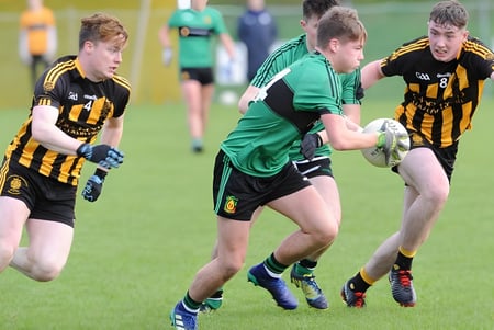 Zwei Spieler beim Rugbyspiel auf dem Spielfeld des St. Macartan's College kämpfen um den Ball.