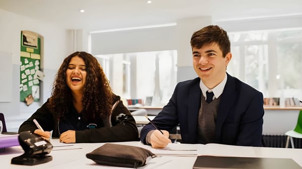 Zwei junge Menschen sitzen an einem Schreibtisch in einem Büro auf dem Campus der St. Margaret’s School.