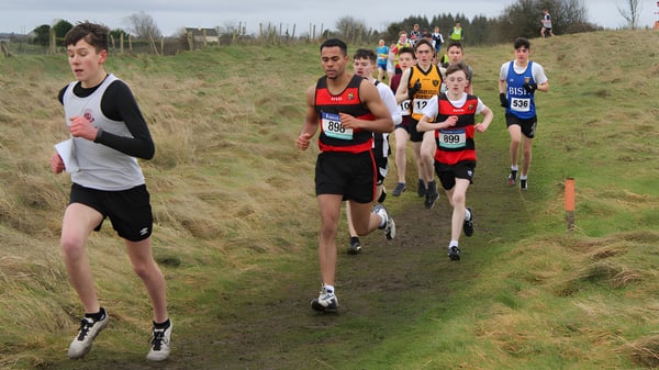 Schüler von St. Mary’s College Ballysadare laufen auf einem grasbewachsenen Waldweg im Gelände.
