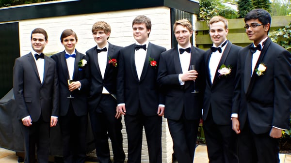 Eine Gruppe junger Männer in formeller Kleidung steht im Außenbereich auf dem Campus von St. Mary’s College Ballysadare.