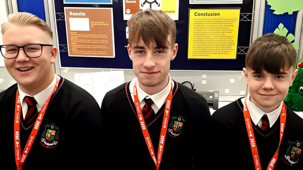 Drei Schüler in Schuluniform stehen vor einer Informationstafel auf dem Campus des St. Marys College Galway.