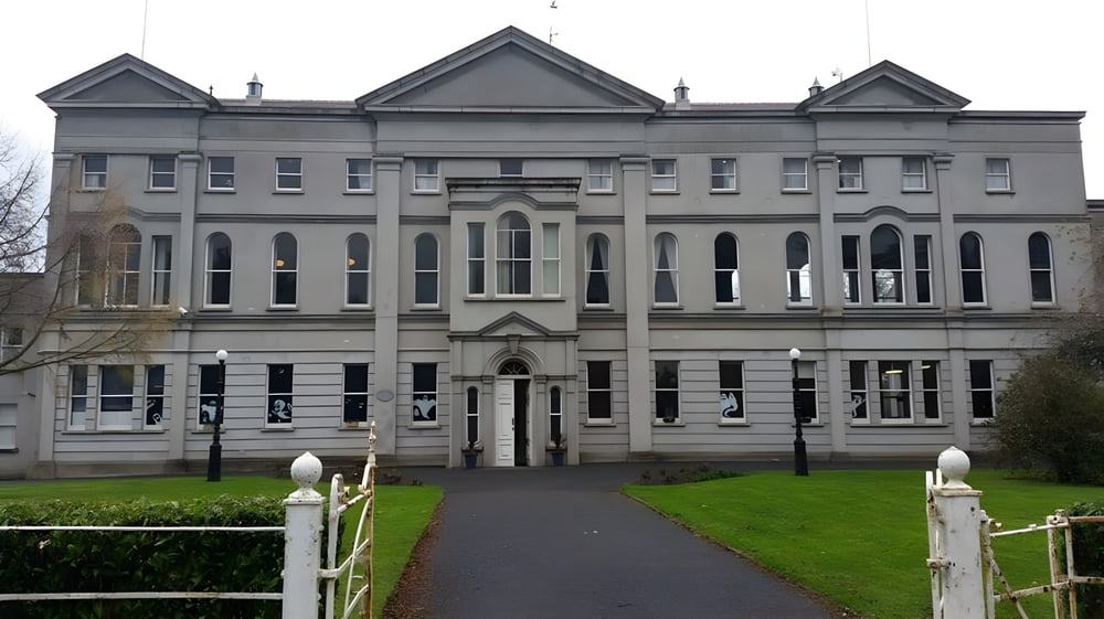 Das prächtige Hauptgebäude von St. Mary’s College mit symmetrischer Fassade und mehreren Giebeln steht hinter einem umzäunten Grünbereich.