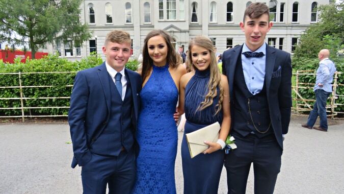 Vier Schülerinnen und Schüler posieren vor einem historischen Gebäude auf dem Campus von St. Mary’s College.