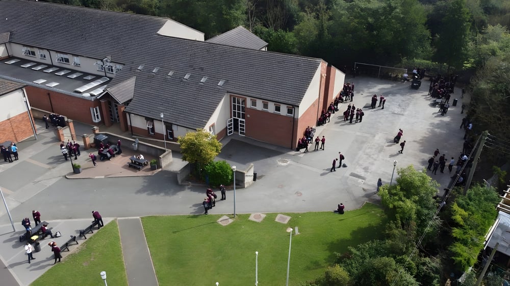 Das mehrstöckige Backsteingebäude der St. Mary’s Diocesan School steht inmitten einer Grasfläche mit Gehwegen, auf denen Menschen gehen.