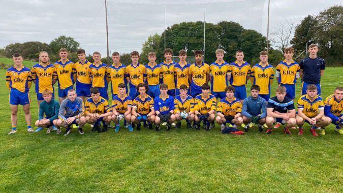 Eine Gruppe Schüler in gelben und blauen Uniformen steht auf einem Grasfeld der St. Mary’s Diocesan School umgeben von Bäumen.