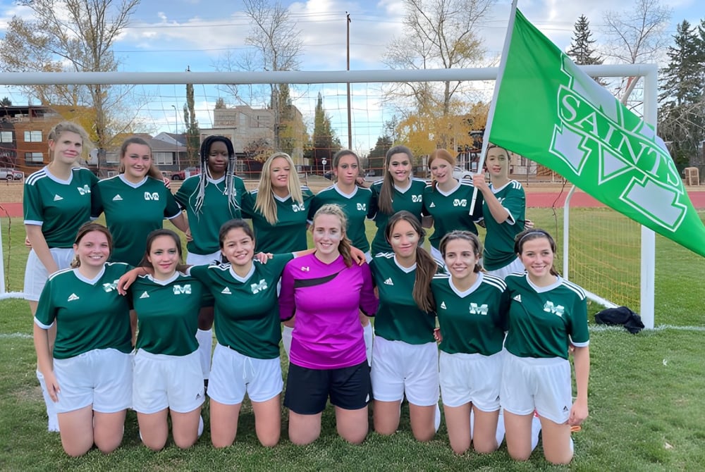 Eine Gruppe junger Fußballspielerinnen steht gemeinsam auf dem Fußballfeld der St. Mary's High School.