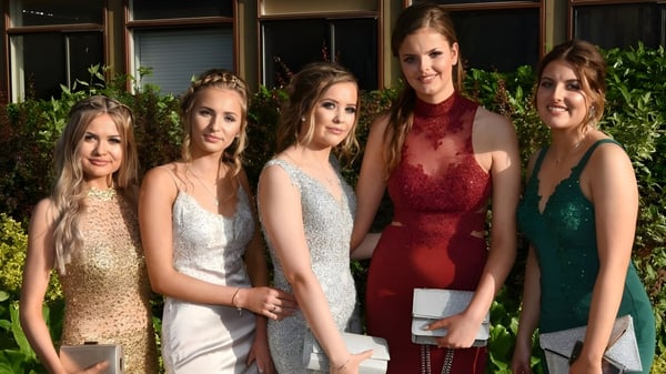 Fuenf Schuelerinnen der St. Mary's Holy Faith Killester posieren vor einem Gebaeude mit Gruenpflanzen.