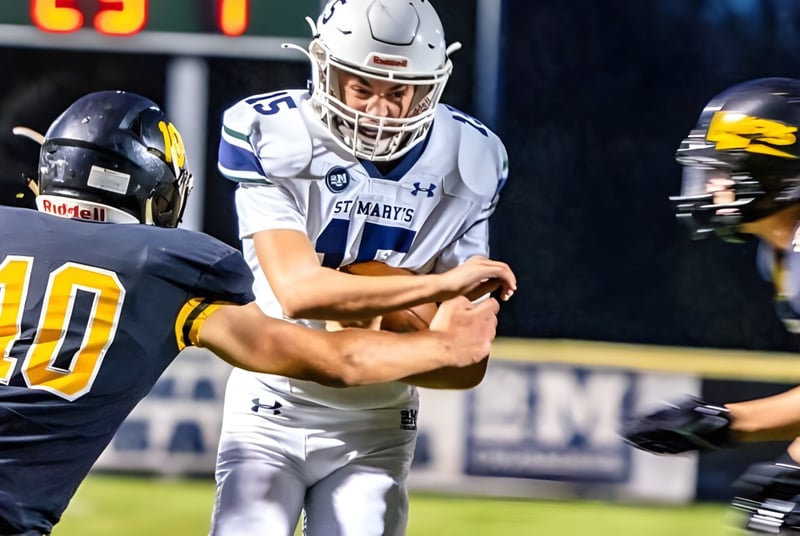 Zwei Footballspieler der St. Mary's School sind in einem Zweikampf auf dem Spielfeld zu sehen.