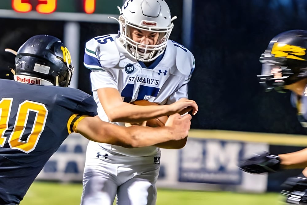 Zwei Footballspieler der St. Mary's School sind in einem Zweikampf auf dem Spielfeld zu sehen.