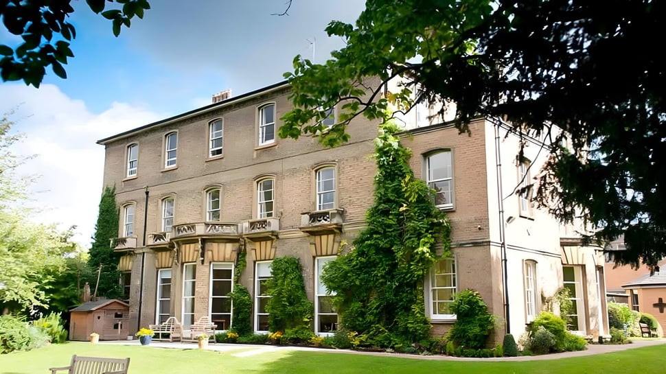 Das mehrstöckige Ziegelgebäude der St. Mary's School ist von Bäumen und gepflegter Vegetation umgeben.
