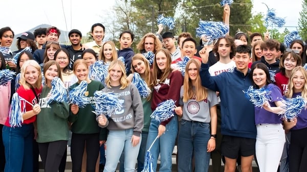 Eine große Gruppe von Schülerinnen und Schülern der St. Mary's School versammelt sich draußen vor Bäumen.