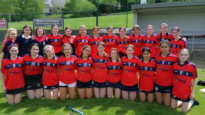 Eine Gruppe junger Athletinnen posiert auf einem Rasenfeld auf dem Gelände der St. Mary's Secondary School in Macroom.