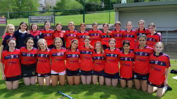 Eine Gruppe junger Athletinnen posiert auf einem Rasenfeld auf dem Gelände der St. Mary's Secondary School in Macroom.