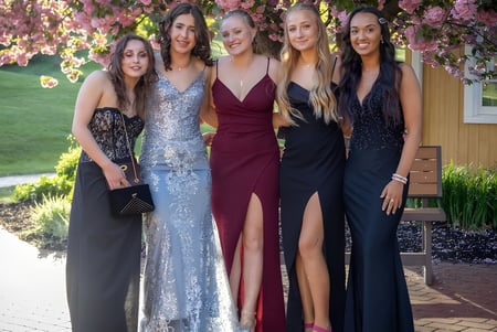 Fuenf Schuelerinnen in Abendkleidern posieren zusammen im Freien auf dem Campus der St. Mary's Secondary School in Charleville.