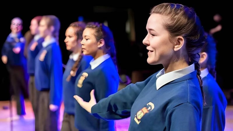 Schüler der St. Mary's Secondary School (Macroom) stehen gemeinsam auf der Bühne und führen eine Aufführung auf.