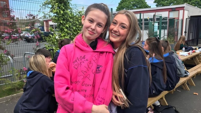 Zwei Schülerinnen mit langen blonden Haaren stehen zusammen und lächeln auf dem Gelände der St. Mary's Secondary School Charleville.