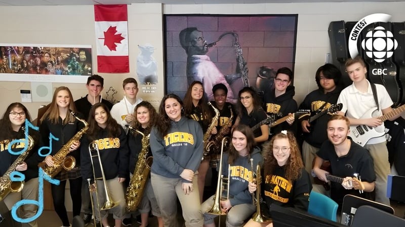 Eine Gruppe Schülerinnen und Schüler der St. Matthew High School posiert mit Musikinstrumenten in einem Raum mit Postern und Dekorationen.