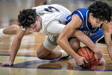 Zwei Basketballspieler kämpfen intensiv um den Ball auf dem Spielfeld der St. Michael's Regional High.