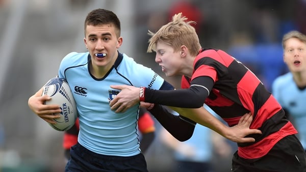 Zwei Rugbyspieler kämpfen auf dem Spielfeld des St. Michael's College, einer trägt ein hellblaues Trikot, der andere rot-schwarz.