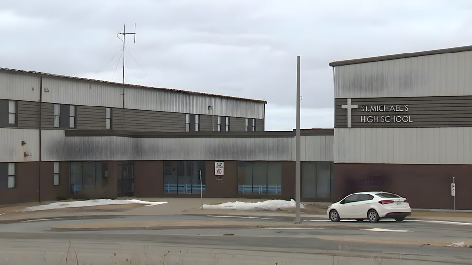 Das große graue Industriegebäude vor dem Parkplatz der St. Michael's Regional High ist zu sehen.