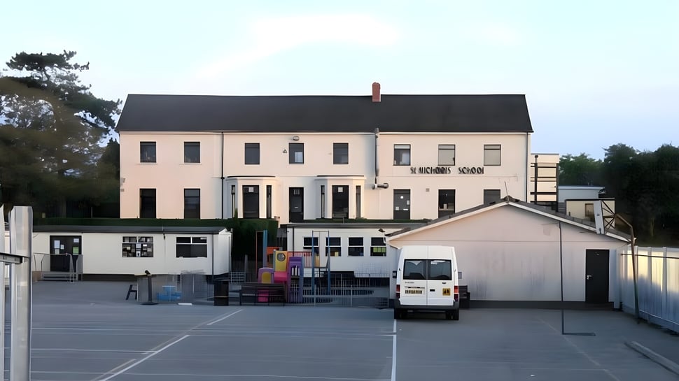 Das mehrstöckige Gebäude mit schwarzem Dach und Vorplatz auf dem Gelände der St. Michael’s School.
