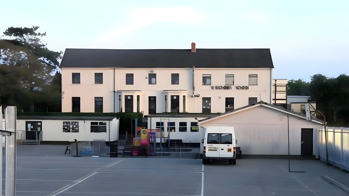 Das mehrstöckige Gebäude mit schwarzem Dach und Vorplatz auf dem Gelände der St. Michael’s School.