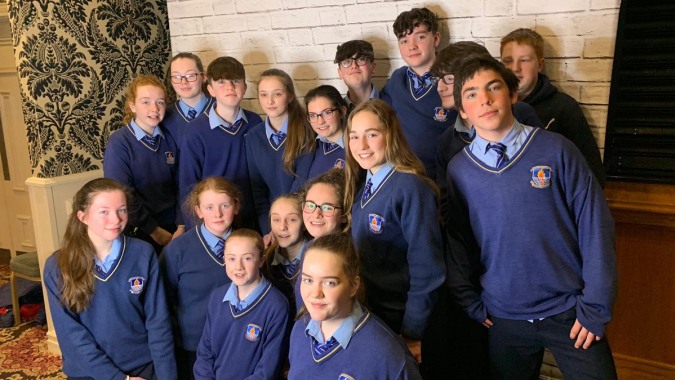 Eine Gruppe Schüler in blauer Schuluniform versammelt sich in einem Raum auf dem Campus des St. Mogues College.