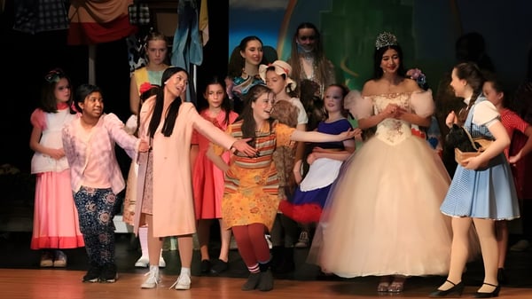 Eine Gruppe von Schülerinnen in farbenfrohen Kleidern führt auf der Bühne der St. Mother Teresa High School eine Performance auf.