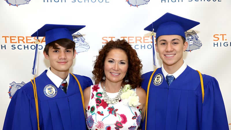 Drei Schülerinnen und Schüler der St. Mother Teresa High School tragen Abschlusskleidung vor einem Hintergrund mit der Aufschrift High School.