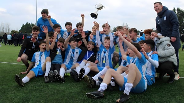 Eine Gruppe junger Fußballspieler vom St. Muredach's College feiert ihren Sieg auf dem Spielfeld.