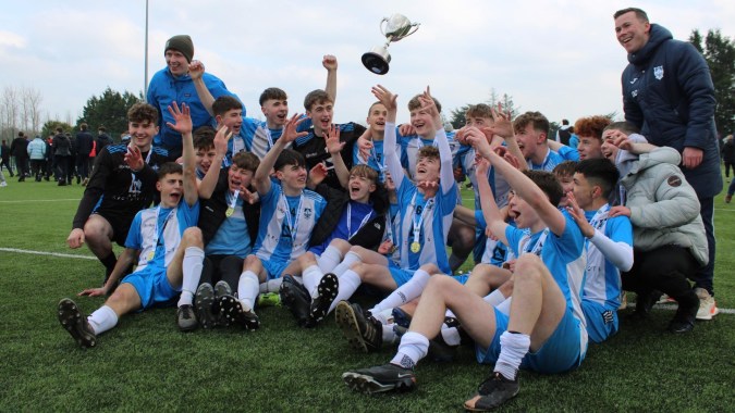Eine Gruppe von Fußball spielenden Schülerinnen und Schülern feiert ihren Sieg auf dem Spielfeld des St. Muredach's College.