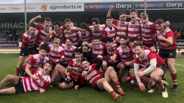 Eine Gruppe von Rugbyspielern des St. Muredach's College feiert gemeinsam auf dem Sportfeld.