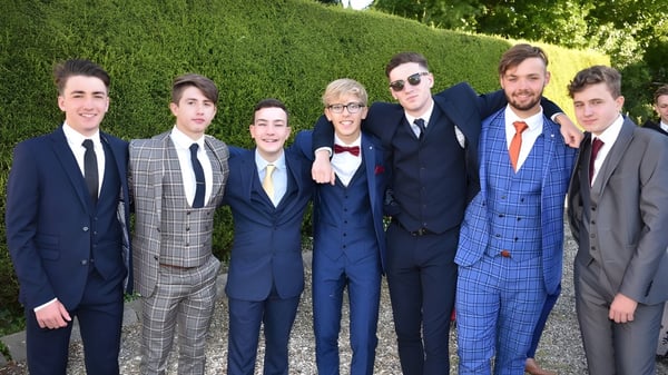 Eine Gruppe von Personen steht im Garten des St. Patrick's College bei einer formellen Veranstaltung.