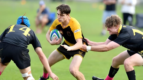 Schüler von St. Patrick's College spielen ein Rugbyspiel und führen einen Tackle auf dem Spielfeld aus.
