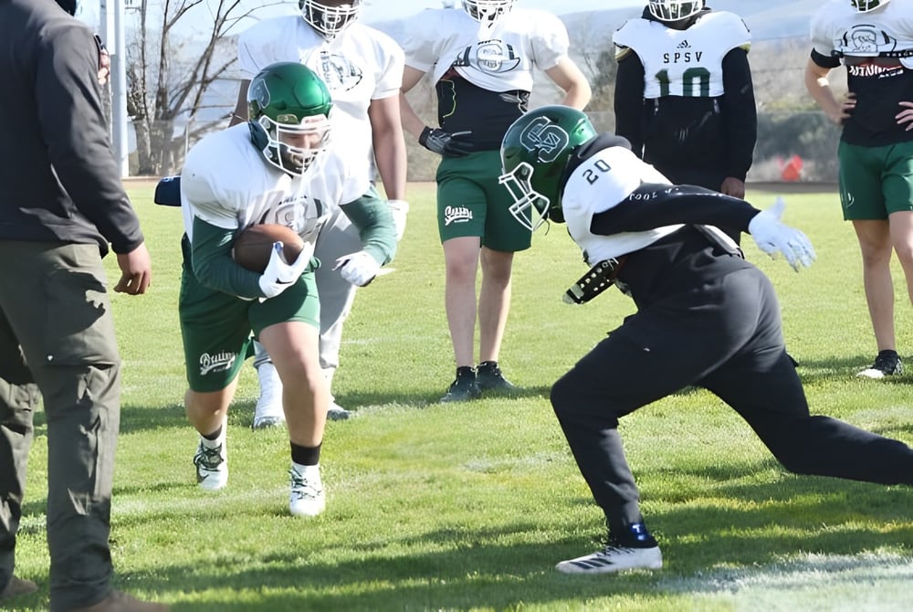 Eine Gruppe von Fußballspielern der St. Patrick's High School trainiert auf einem Rasenplatz.