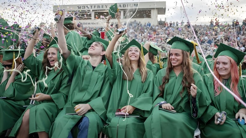 Absolventinnen und Absolventen der St. Patrick's High School feiern im grünen Gewand mit Konfetti.